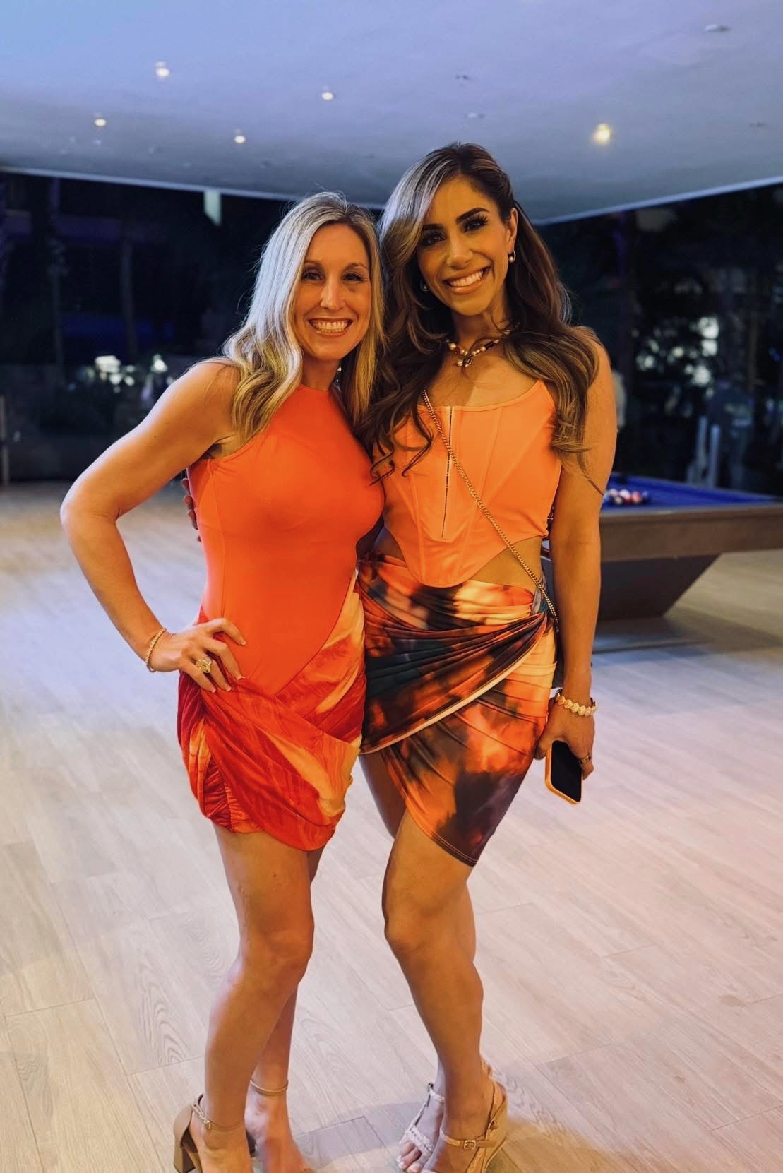 Alissa Meisel and Hanieh, EllieMD team partners, in matching orange outfits