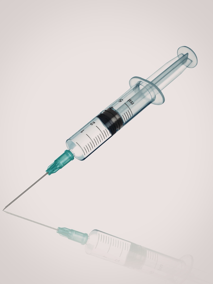Elegant syringe on reflective surface representing PT-141 and sexual health protocols